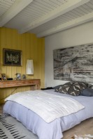 Large artwork above bed in country bedroom 