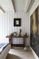 Rustic wooden table and artwork in country bedroom