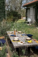 Rustic outdoor dining table laid for lunch outside country home