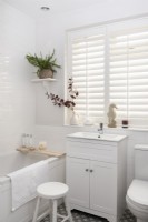White modern bathroom with plantation shutters
