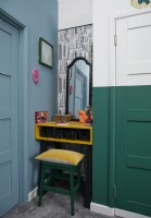 Bedroom detail of dressing table with blue and green painted walls.