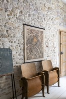 Vintage wooden cinema seats against exposed stone wall