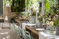 Childs swing next to rustic outdoor dining table laid for lunch 