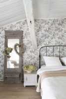 Romantic country bedroom with floral wallpaper