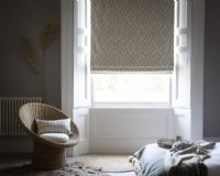 Bedroom with wicker chair and patterned roman blind
