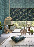 Hanging chair in front of tropical themed roman blinds and wallpaper