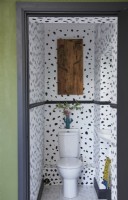 Downstairs toilet with patterned wallpaper and cactus wall art.