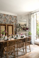 Eclectic dining room with wicker furniture and floral wallpaper