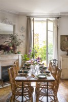 Dining table next to open French windows in retro style dining room
