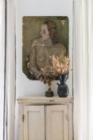 Vintage painting above distressed wooden cabinet - detail