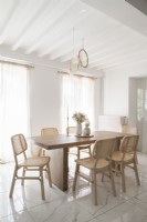 White dining room wtih pale wooden furniture