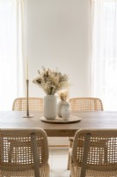 Dried flower arrangements in centre of wooden dining table