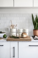 Chopping board and utensil jars on worktop of modern kitchen