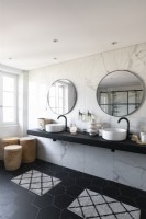 Twin sinks in contemporary monochrome bathroom with marble wall