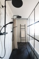 Large shower cubicle with crittall windows and ladder towel rail