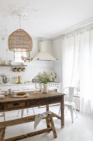 White country style kitchen with wooden farmhouse table and bench
