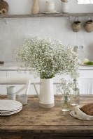 White flowers on wooden table in country kitchen