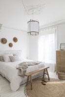White country bedroom with wooden and rattan furniture