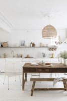 White country kitchen-diner with wooden table and bench
