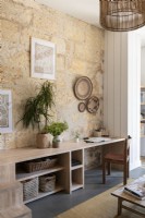 Built-in desk and shelves against exposed stone wall