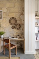 Desk and chair against exposed stone wall