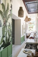 Tropical wallpaper and green panels in modern galley kitchen