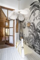 Grey and white tropical patterned wallpaper over staircase