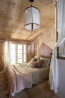 Modern country bedroom with wooden walls and ceiling