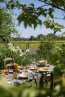 Outdoor dining table in country garden laid for lunch in summer