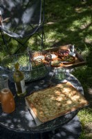 Food and wine on reclaimed cable reel table in country garden