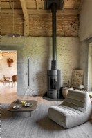Modern chair and wood burner in converted barn living room