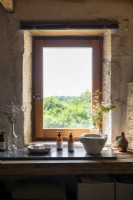 Countryside view though window in rustic bathroom