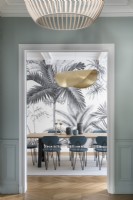 View into dining room with grey patterned wallpaper and gold light