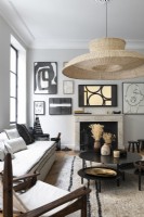 Large lampshade and display of artwork around fireplace in living room