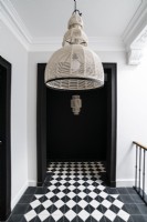 Unusual lampshade over checked floor on upstairs landing
