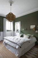 Modern green and white bedroom with wicker lampshade pendant light
