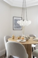 Round wooden dining table with pendant light