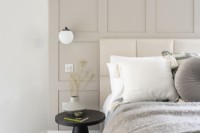 Detail of modern bed with padded headboard and bedside table