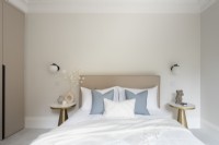 Detail of bed with padded headboard and bedside tables
