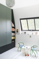 Tiny table and chairs in modern childrens room with built-in cupboards