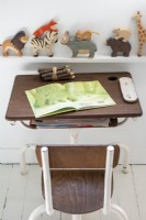 Shelf of animal ornaments above vintage desk and chair set