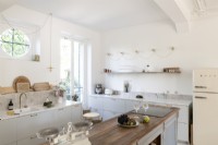 Circular window above sink in modern country style kitchen