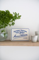 Detail of kitchen shelf with vintage sign and herbs in vase