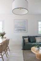 Open plan living and dining space with coastal painting on wall