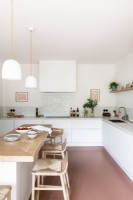 Modern white kitchen with pink flooring