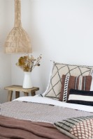 Black, white and brown cushions on bed in modern country bedroom