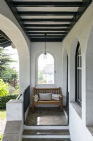 Bench at top of stairs in exterior alcove of villa