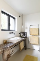 Reclaimed rustic wooden workbench in bathroom with sink