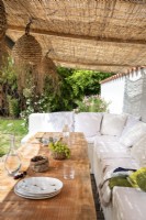 Outdoor dining area under sisal canopy 