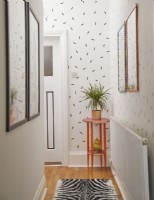 Hallway with confetti washi tape wall, framed artwork and a pink plant table.